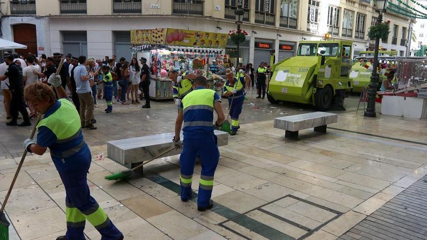 Operarios de Limasa en plena faena tras un día de Feria en la calle Larios.