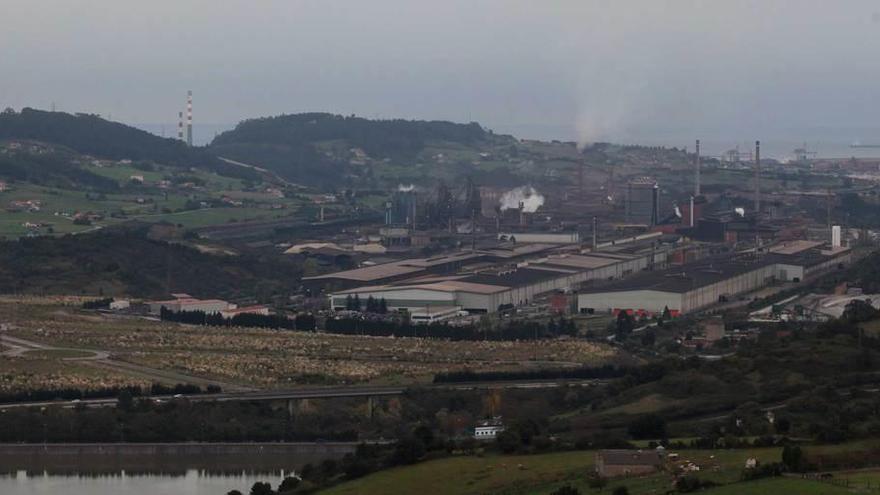 Terrenos de la Zalia a la izquierda de la factoría de Arcelor Mittal en Gijón, con el puerto de El Musel al fondo.