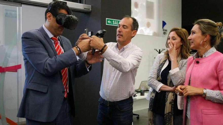 El delegado de la Junta, Alberto Castro, prueba las gafas 3D en presencia de la directora de Telecomunicaciones, María Victoria Seco (dcha).