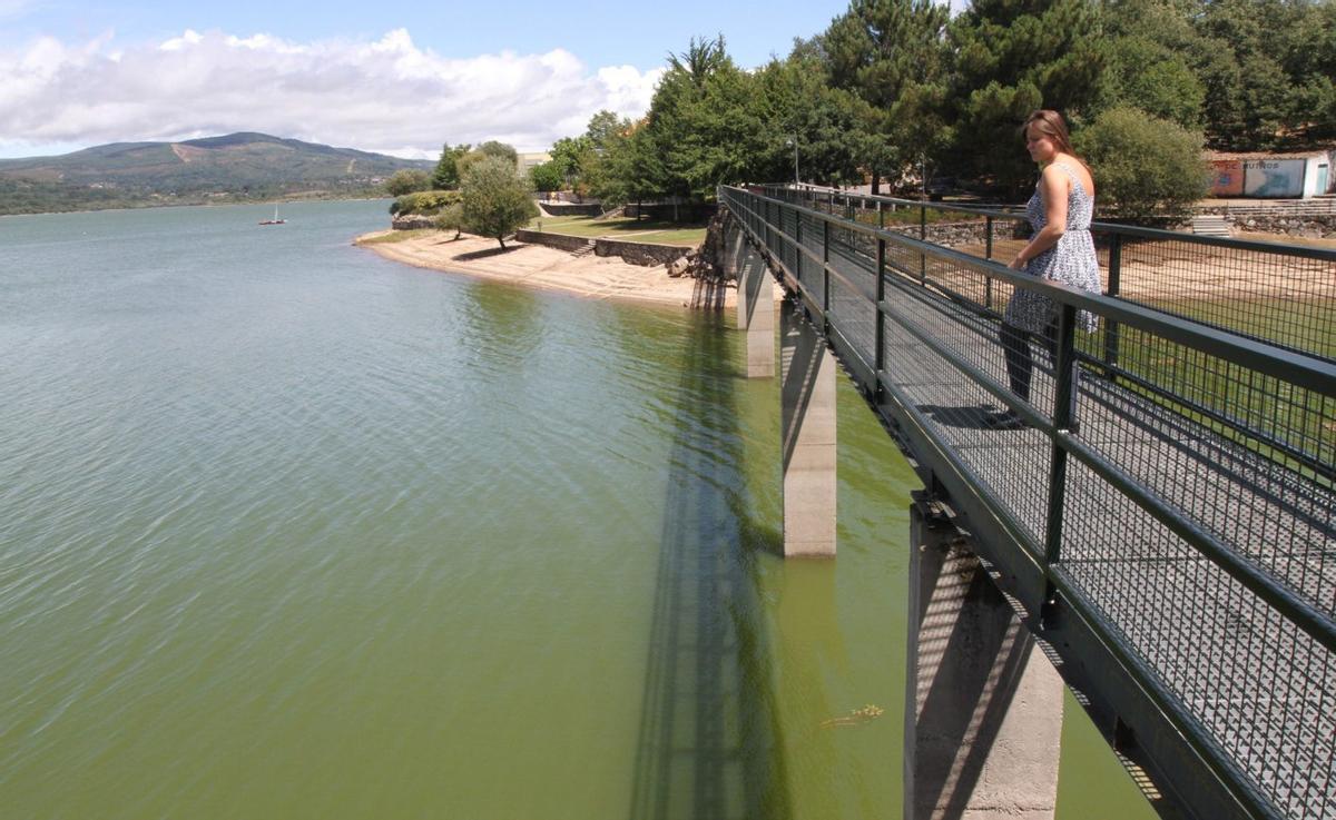 Parte de los vecinos que llevaron a cabo las movilizaciones caminan frente al embalse de As Conchas. | IÑAKI OSORIO