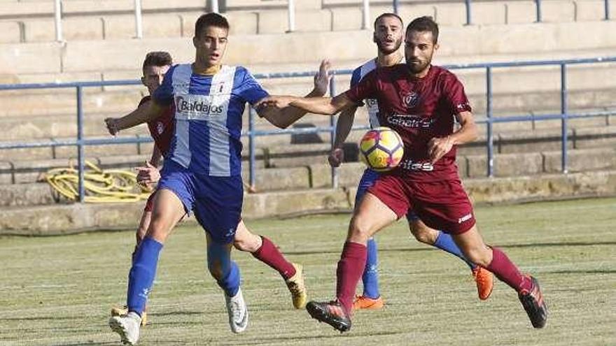 El blanquiazul Jorge y Edu, del Llaranes, disputan un balón.