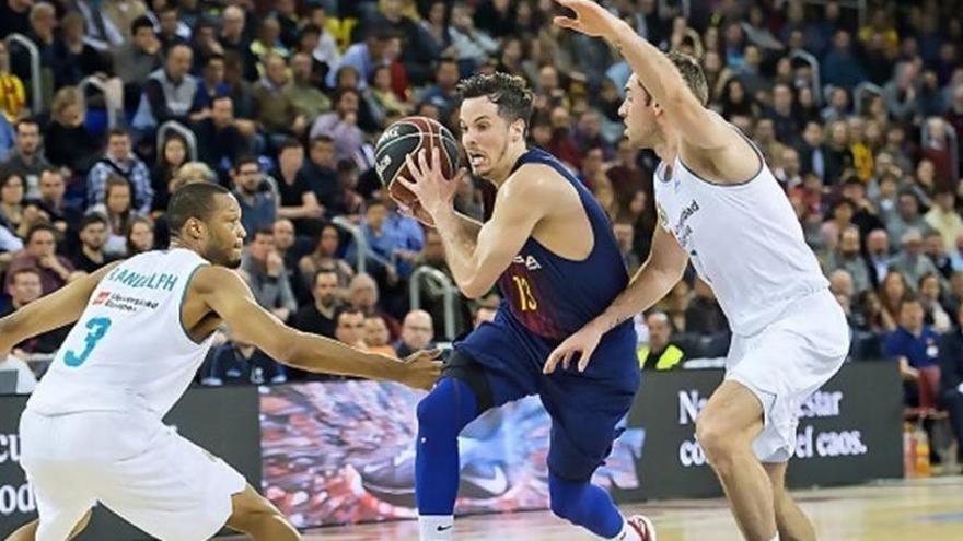 Heurtel avanza con el balón ante dos jugadores del Madrid.