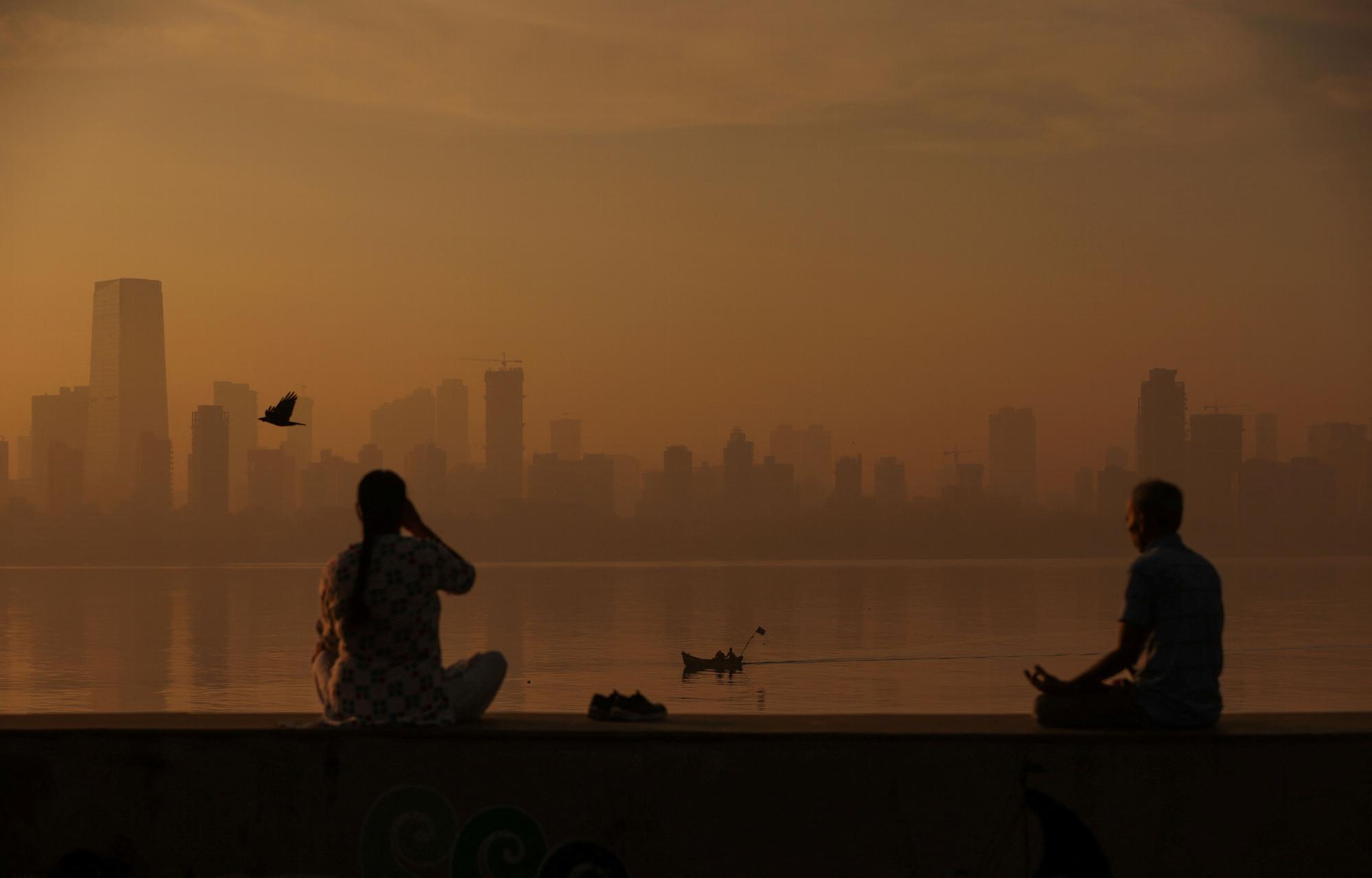 People exercise at a promenade on a smoggy morning in Mumbai