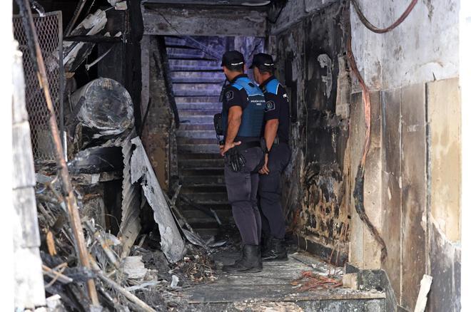 Dos agentes en el portal del edificio incendiado en la calle Alfonso X.