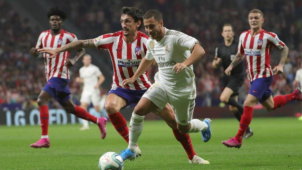 Savic intenta frenar el avance de Hazard durante el último derbi madrilleño