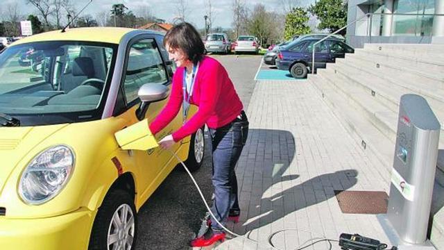 Paula Queipo, de Prodintec, durante la carga del vehículo eléctrico de la Fundación en su antigua sede.