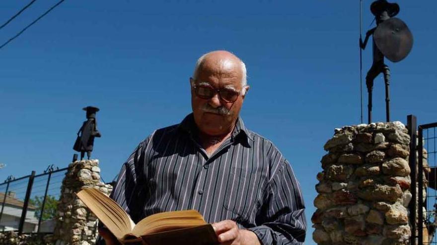 Domingo Andrés posa con El Quijote frente a las figuras del caballero andante y Sancho Panza de su jardín.