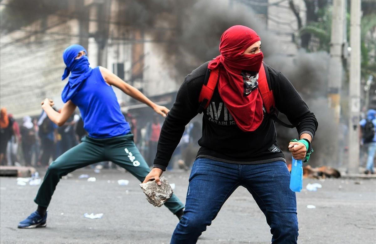 Los estudiantes de secundaria y del Instituto Nacional de Formación Profesional (INFOP) se enfrentan con la policía antidisturbios durante una protesta contra el presidente hondureño Juan Orlando Hernández en los alrededores del edificio del Congreso en Tegucigalpa.