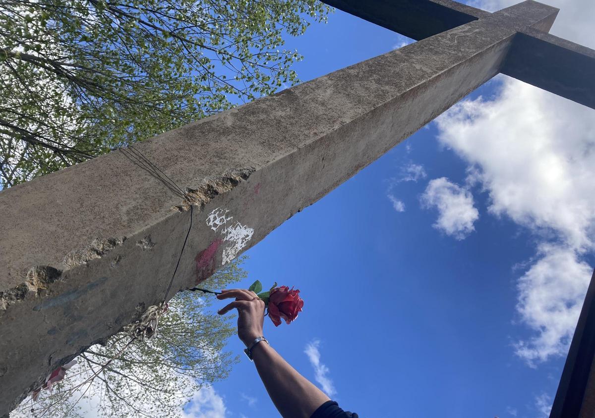 Una persona neta de dos dels afusellats al Còrrec del Gavatx diposita una flor a la creu, un dels escenaris de mort de la Guerra Civil