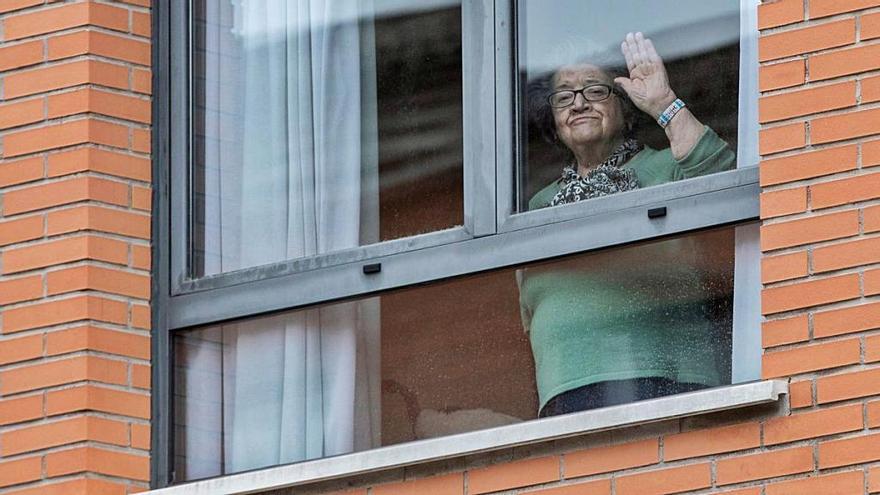 Una usuaria de una residencia de Murcia con decenas de casos confirmados se asoma a una de las ventanas del centro, ayer.