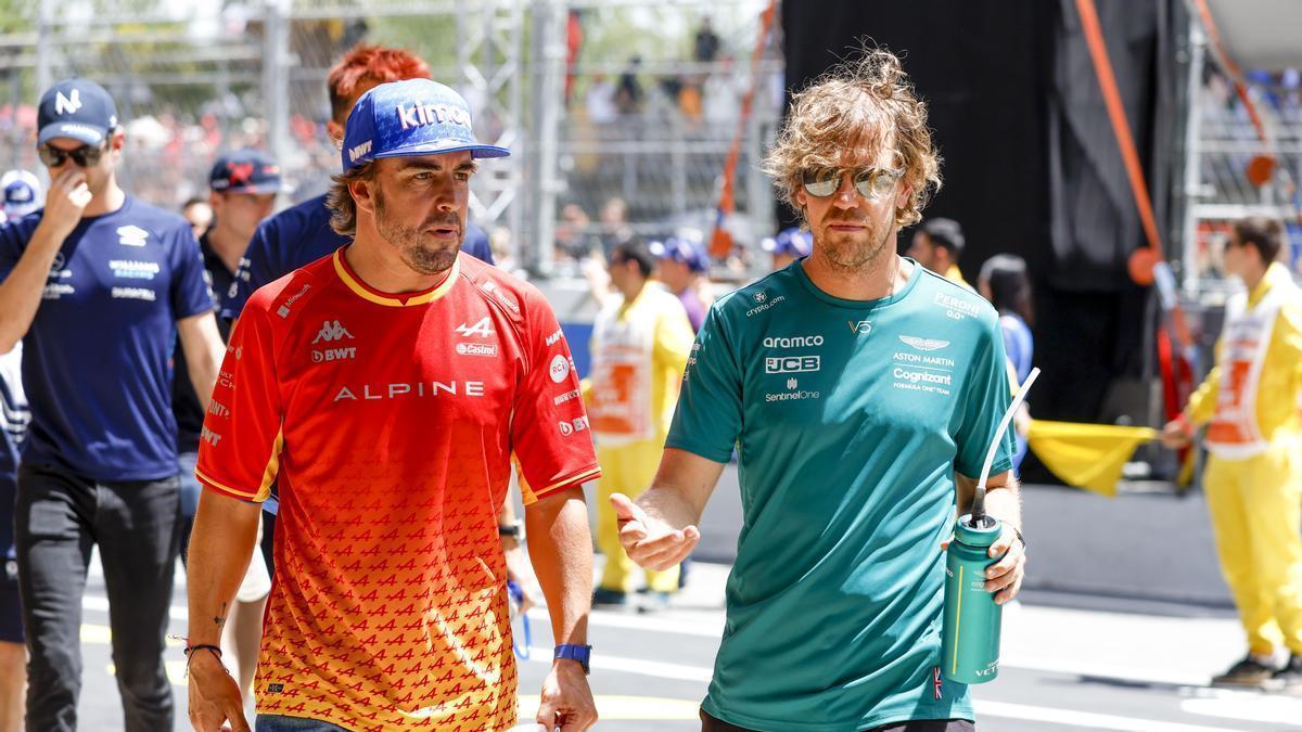 Alonso pasea por el pit lane junto a Sebastian Vettel durante el GP de España