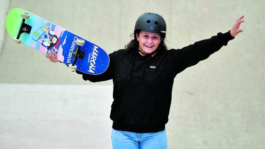 Julia Benedetti, con su ‘skate’  en la mano, estira los brazos  en las instalaciones del Maroña Skatepark, donde se entrena  en A Coruña. // VÍCTOR ECHAVE
