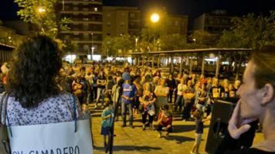 Una vecina con un cartel denunciando un caso laboral, dirigiéndose a los presentes, y, a la derecha, pitada-cacerolada.