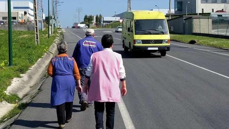 Vecinos caminan por un arcén de la avenida Arsenio Iglesias, en Sabón.