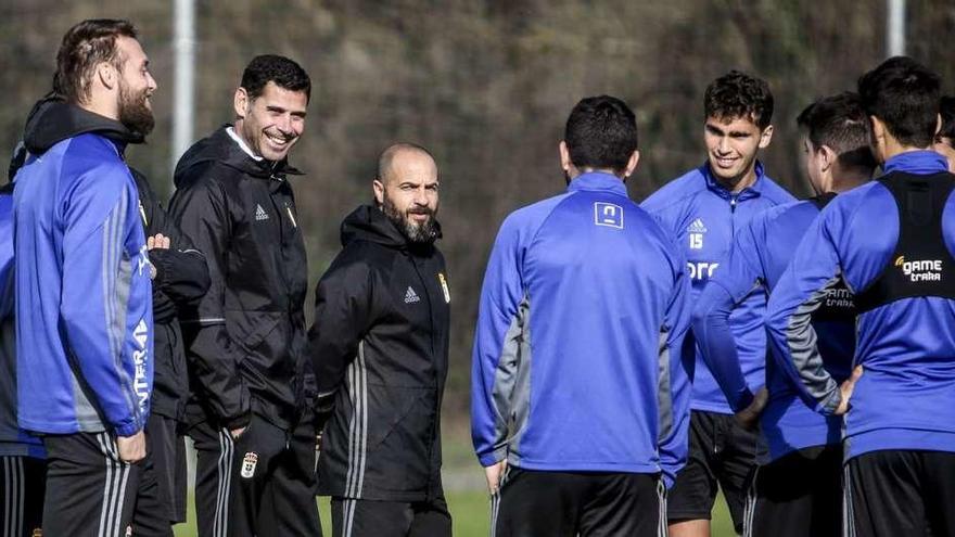 Fernando Hierro (segundo por la izquierda) y el preparador físico Roberto Ovejero (tercero) conversan con varios futbolistas del Oviedo, ayer.