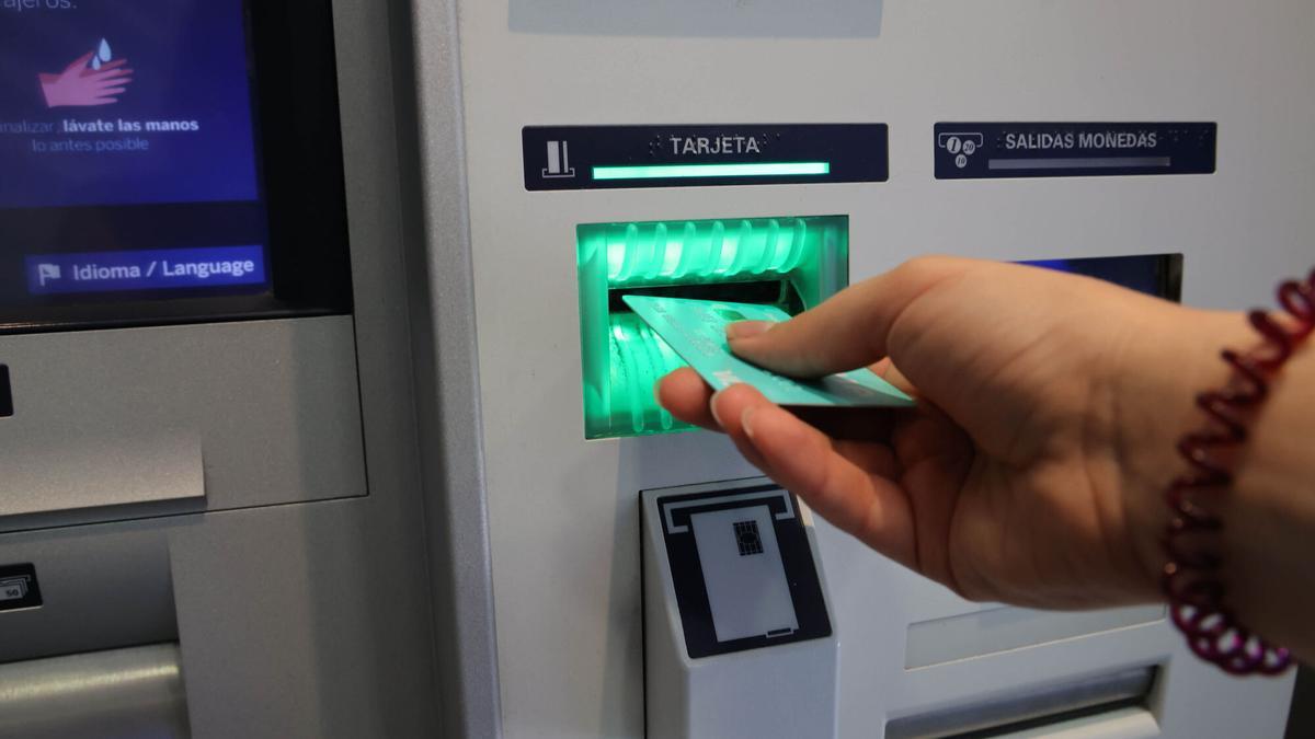 UNA MUJER RETIRA DINERO DE UN CAJERO AUTOMÁTICO.