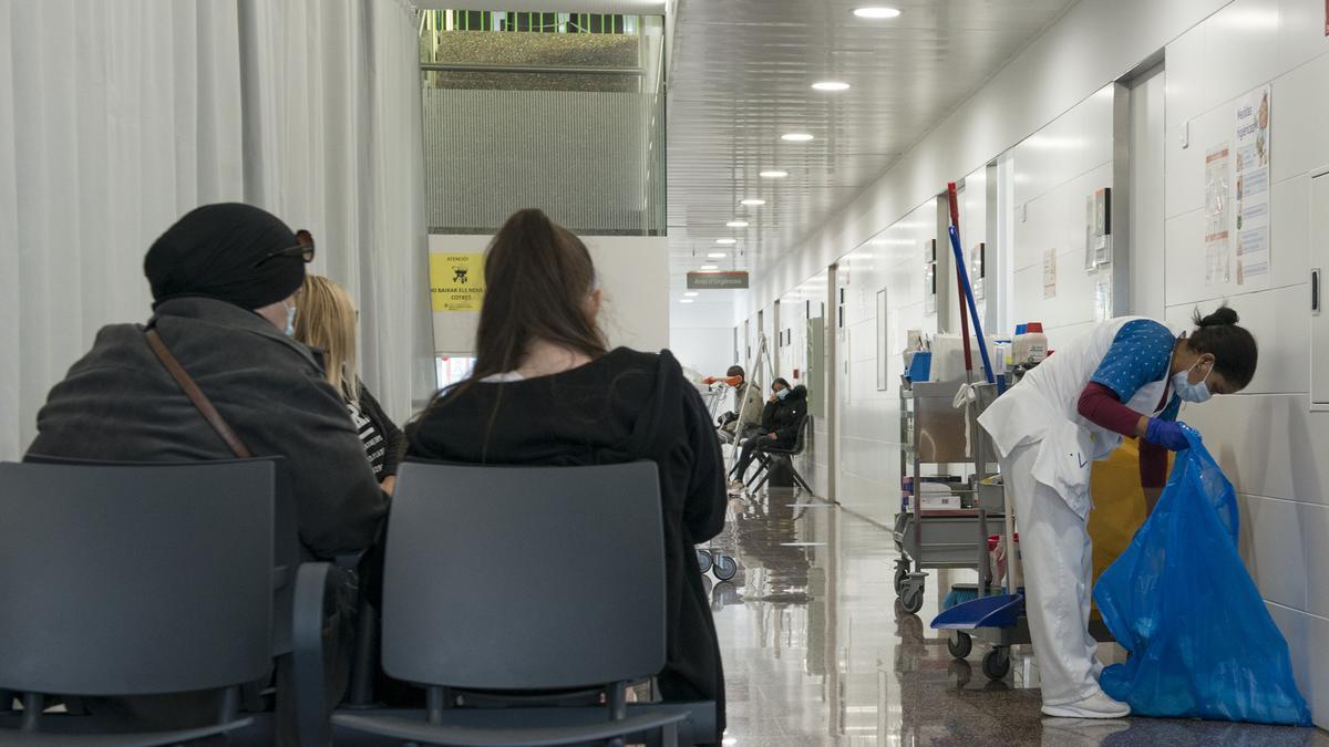Varias pacientes esperan en una sala de espera mientras una mujer limpia en el CAP Masdevall el día en el que comienza la campaña de vacunación antigripal en la región, en Figueres, Girona (Catalunya), a 16 de octubre de 2020.La campaña coincide
