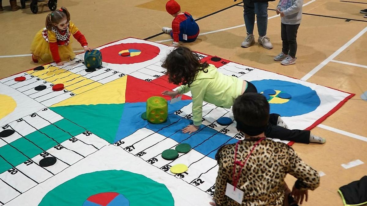 Unos niños, jugando a un parchís gigante.