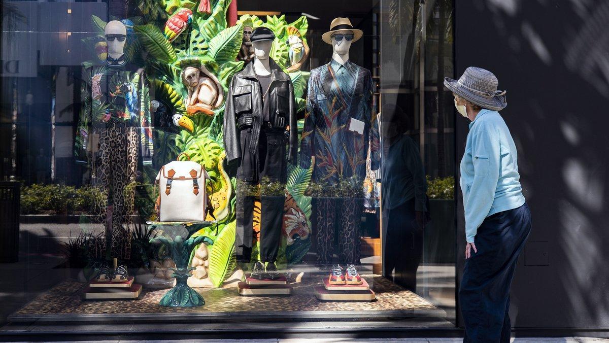 Beverly Hills (United States), 20/05/2020.- A woman wearing face mask looks at the window of luxury shop ’Dolce & Gabbana’ on Rodeo Drive amid the coronavirus pandemic in Beverly Hills, California, USA, 20 May 2020. Retail shops in California are allowed to be open for curbside pickup. (Abierto, Estados Unidos) EFE/EPA/ETIENNE LAURENT