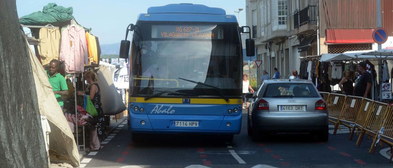 Un autobús y un coche se detienen al cruzarse y percibir sus conductores que el ancho de la calzada era insuficiente.  | // NOÉ PARGA