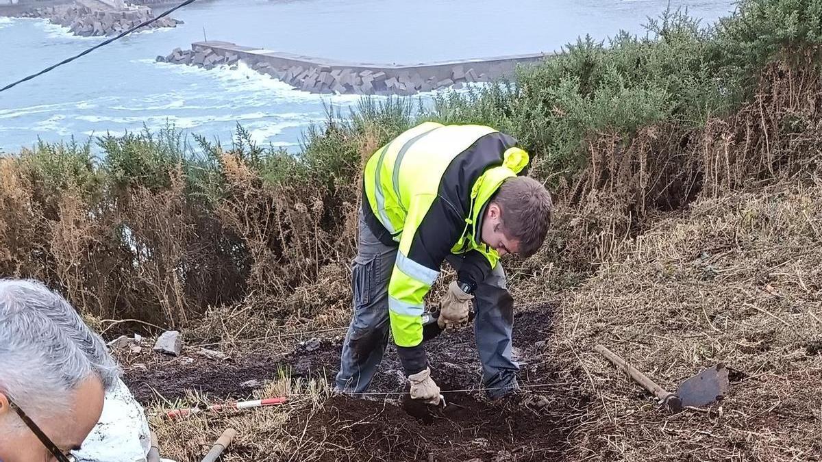 Los restos descubiertos en Puntamuyeres y, al fondo, la villa de Luarca.