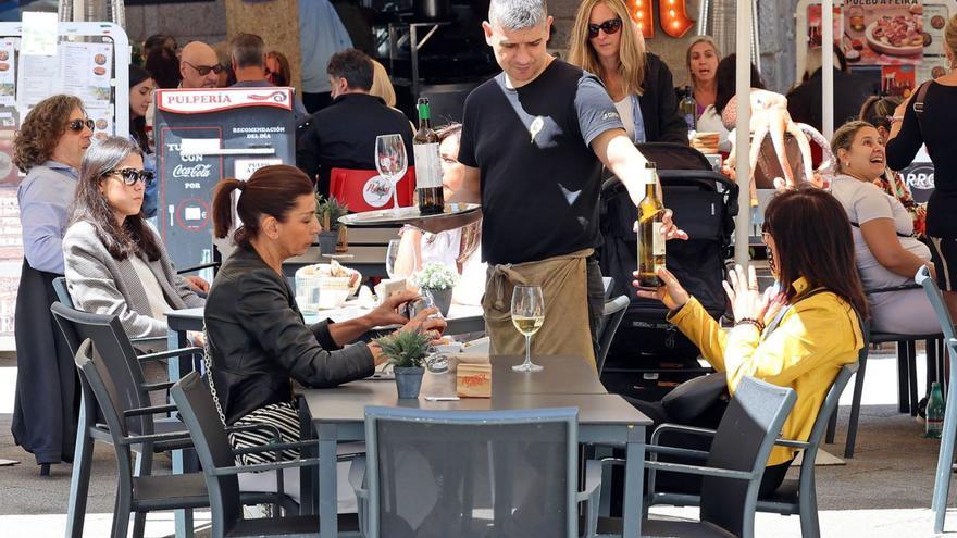 Un camarero atiende a dos clientas en una terraza. | Marta G. Brea