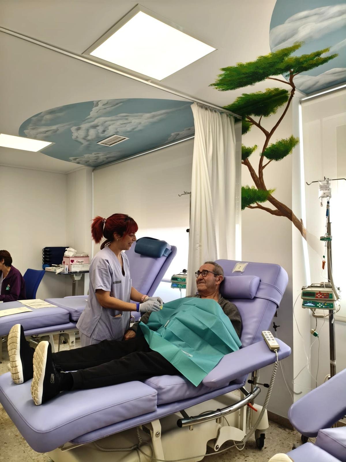 Un paciente junto a una trabajadora sanitaria en el hospital de día.
