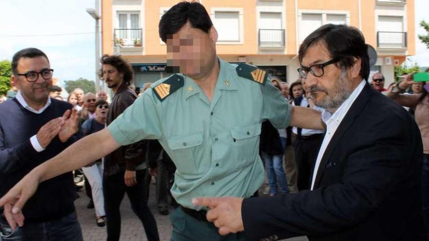 El nuevo alcalde de Miño, ayer, escoltado por la Guardia Civil tras el pleno.