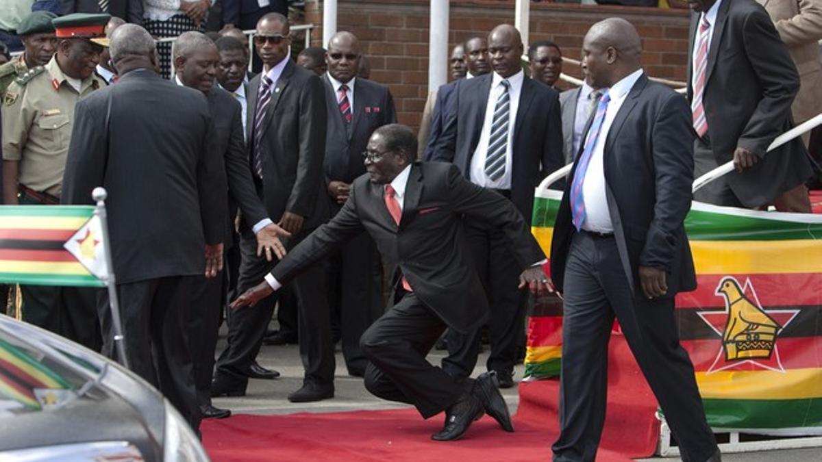 El presidente de Zimbabue Robert Mugabe tropezando tras un discurso este lunes en un aeropuerto en su país.