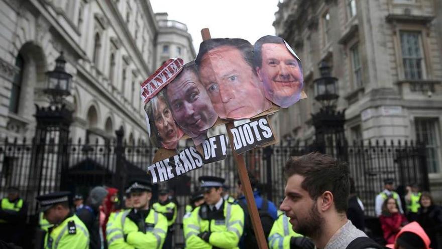 Policías protegen de los manifestantes el acceso a la residencia oficial de Cameron en Londres.