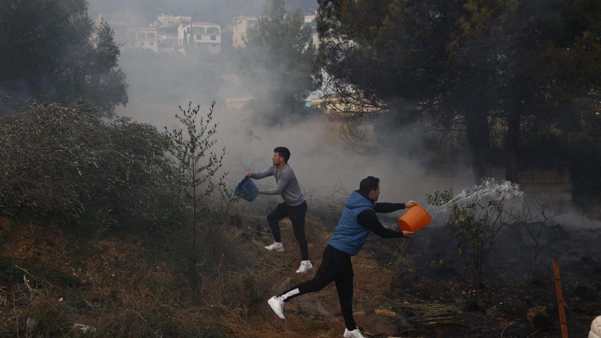 Vecinos tirando cubos de agua