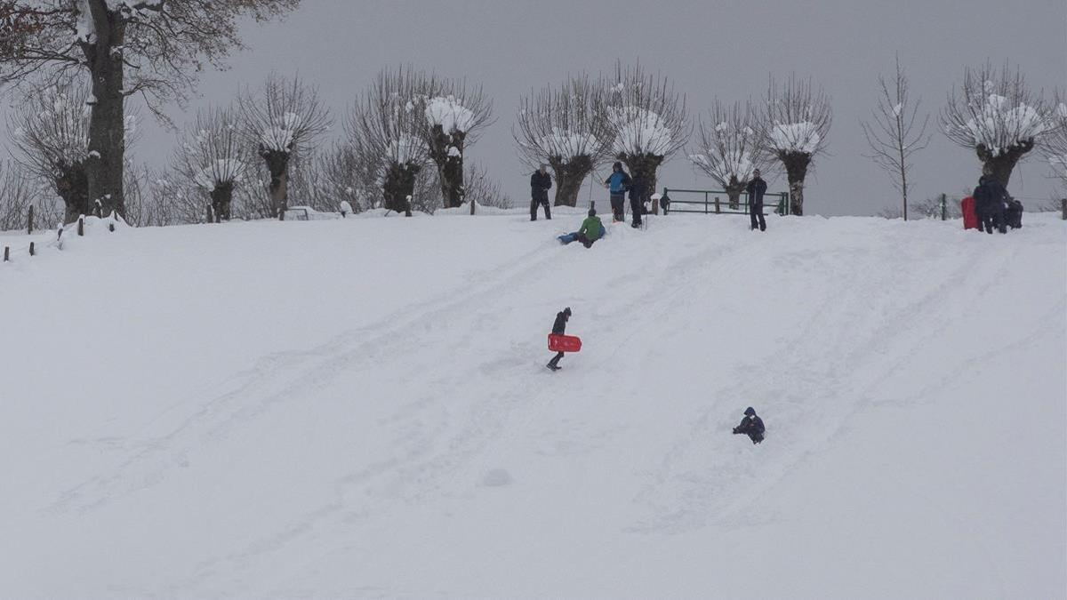 Varias familias se divierten en la nieve acumulada en Roncesvalles, Navarra.