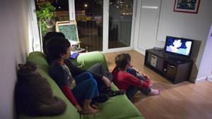 Una familia, ante el televisor de su casa. Las cadenas, según la reforma horaria, deben avanzar su ’prime time’. 