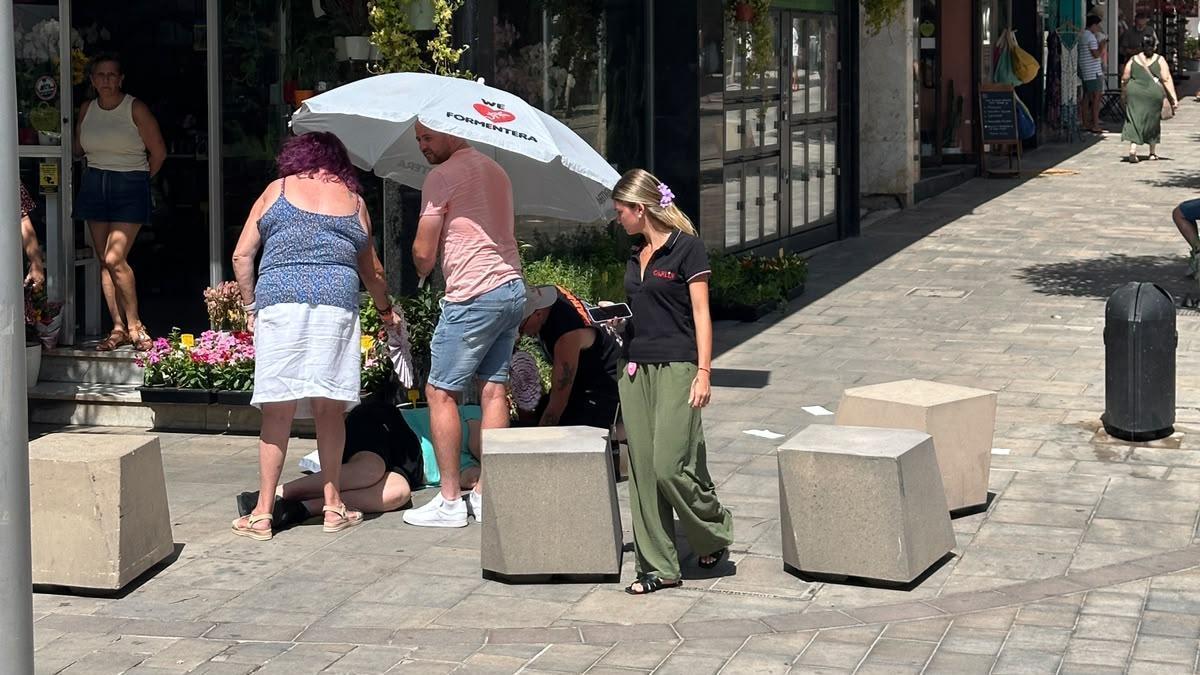 La mujer, junto a varios vecinos, tirada en la calle de Santa Eulària.