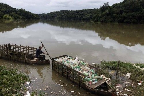 Roberto da Silva empuja uno de los botes con plástico que ha recuperado del río Tiete en Sao Paulo