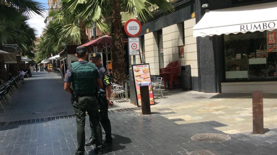 Agentes de la Guardia Civil esta mañana y a la derecha, bajo la señal, sobre un pivote, el paquete que ha generado la alarma