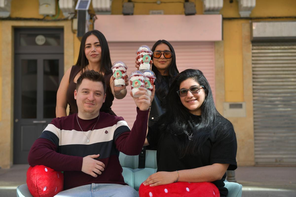 El repostero Vlad Barligea, junto a sus socias, posa con sus fresas delante de su local en la calle del Socorro.