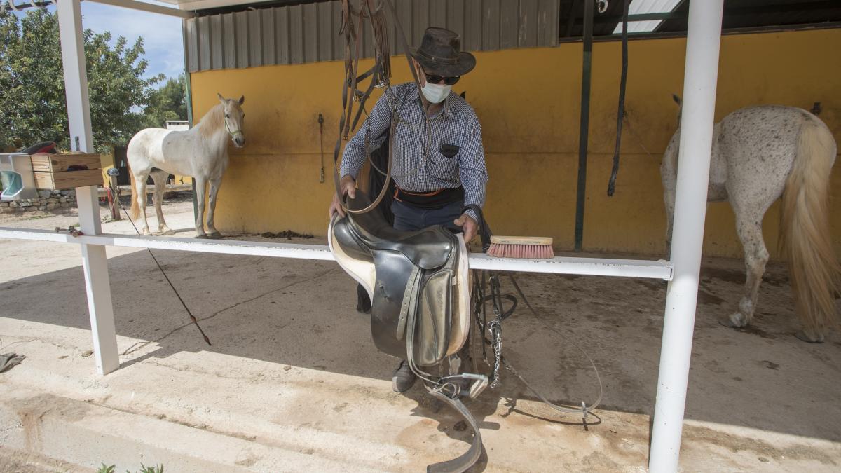 Paco desmonta a uno de los caballos antes de ir a ducharles.