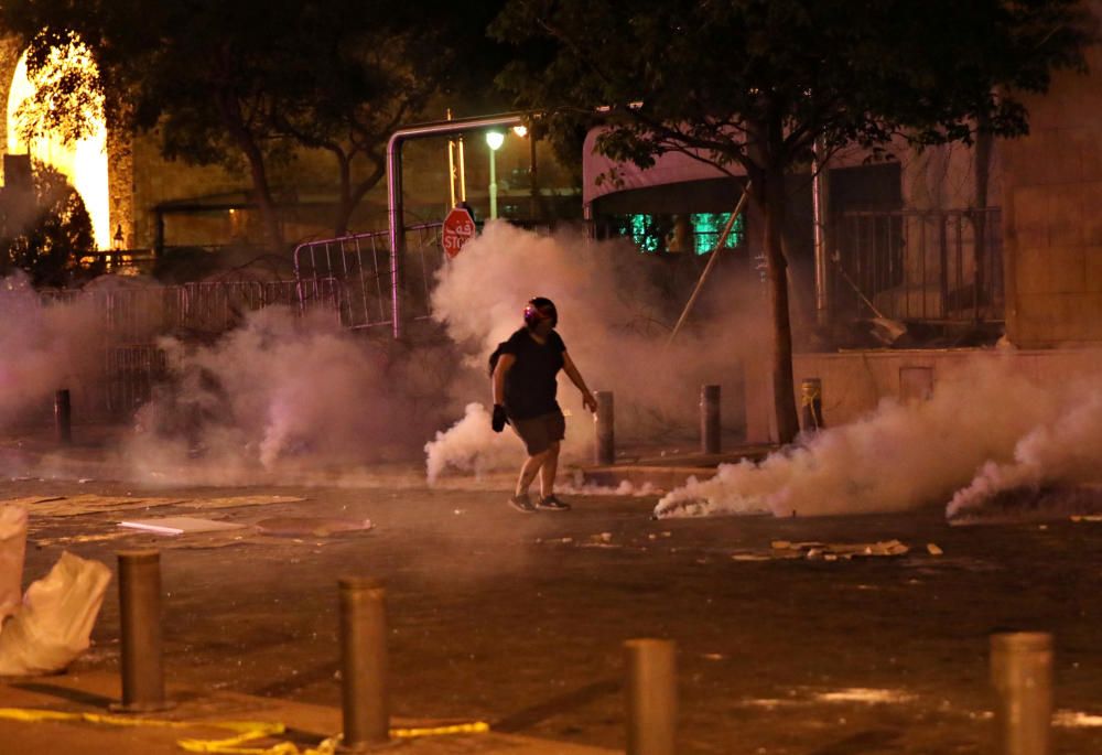 A demonstrator is pictured amid smoke rising ...