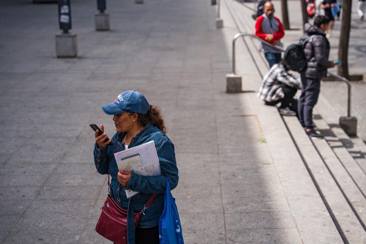 Caos y una larga cola de personas que esperan regularizar su situación en España en la Oficina de Benestar Social i Família de Barcelona-Sants/Eixample.