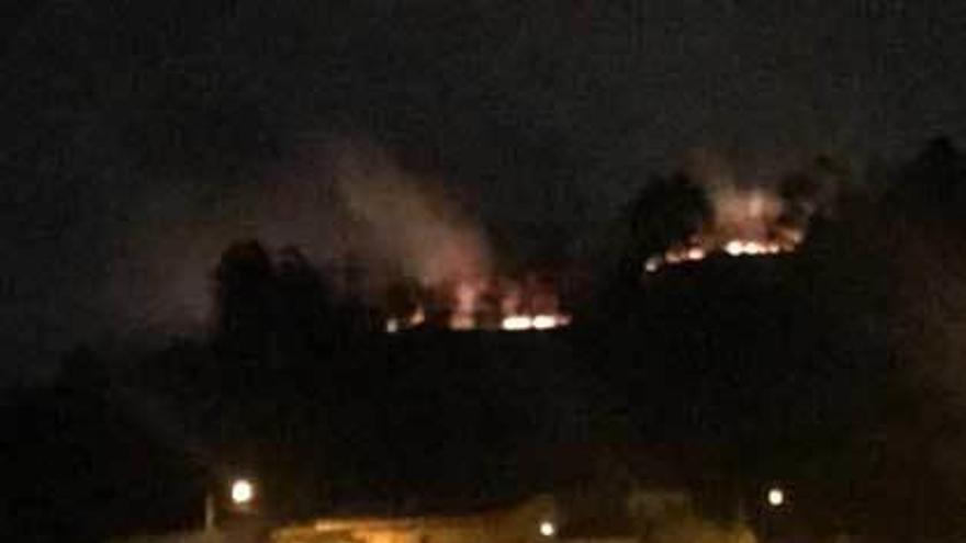 El incendio de Turón, en la zona alta del monte, amenazando en su avance a un grupo de viviendas.