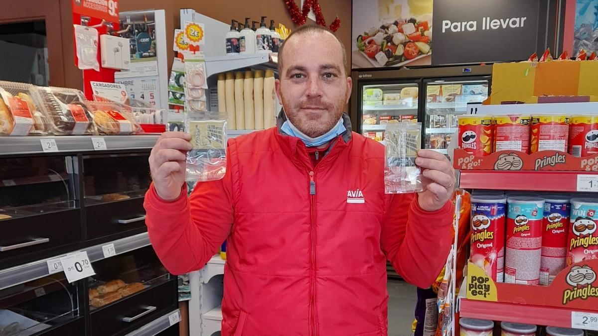 El empleado de una gasolinera muestra los ambientadores que se regalan a los conductores.