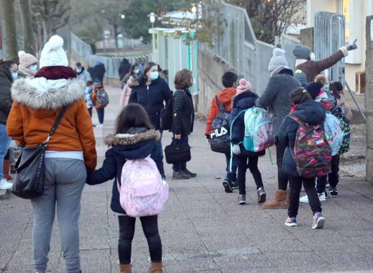 Padres con sus hijos en el acceso de un centro Primaria en Santiago. |   // XOÁN ÁLVAREZ