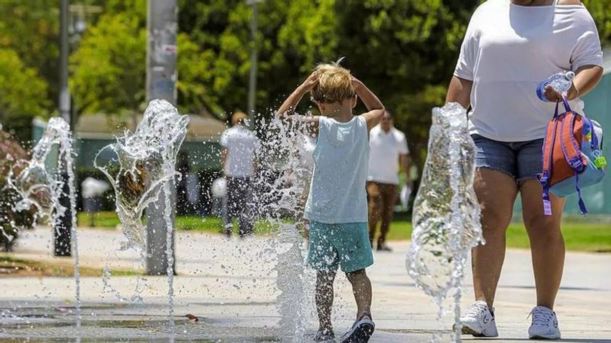 Ein Kind erfrischt sich an einem öffentlichen Brunnen auf Mallorca