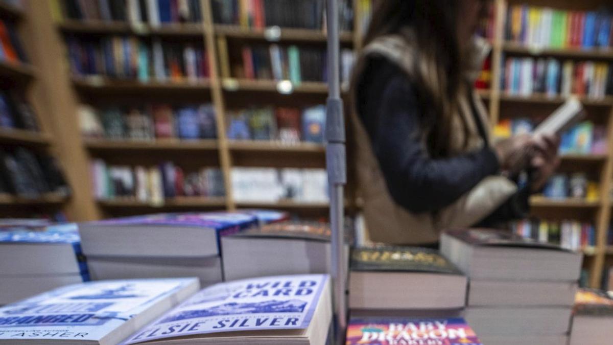 Diversos estudiants compren novel·les en anglès en una llibreria. | JORDI OTIX