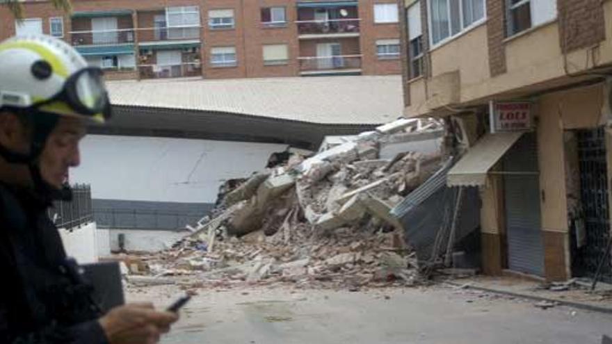 Un miembro de seguridad ante un edificio derruido en Lorca.