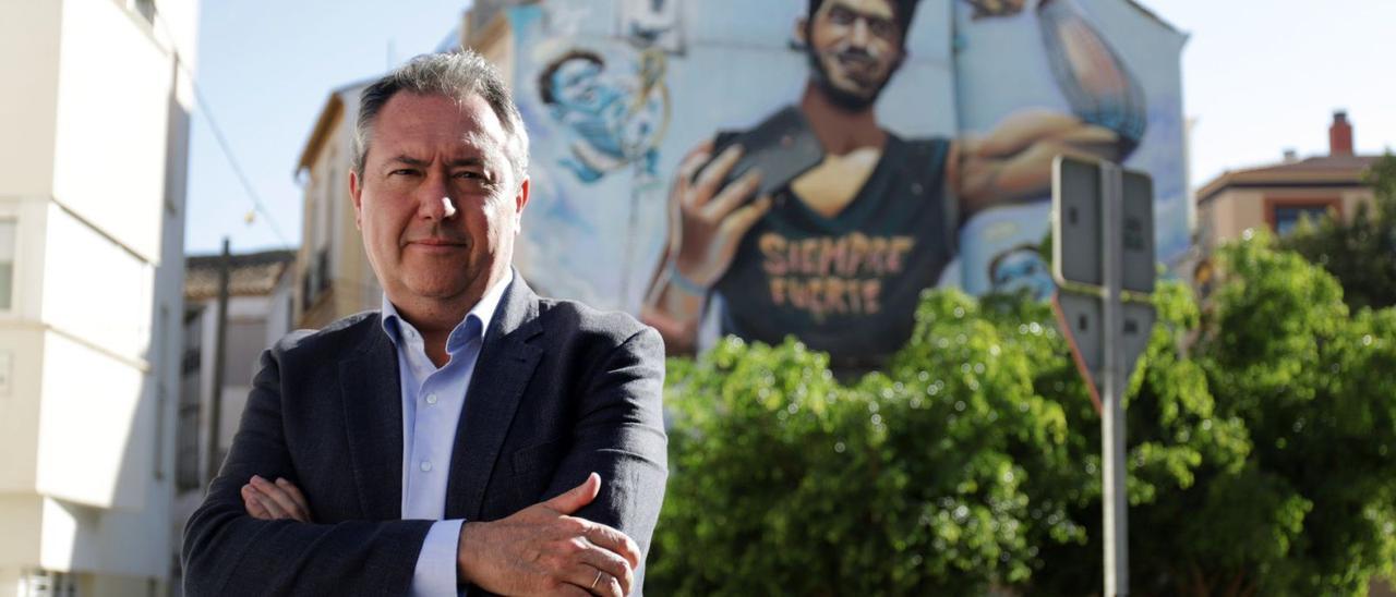 El candidato del PSOE, Juan Espadas, junto al grafiti que recuerda a Pablo Ráez en el barrio malagueño de Lagunillas. | ÁLEX ZEA