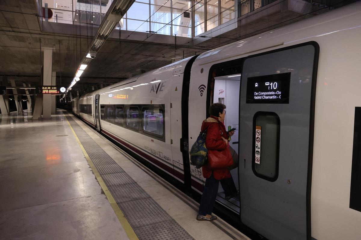 Una viajera sube a un tren Avril (S-106) de Renfe en la estación de Vigo-Urzáiz