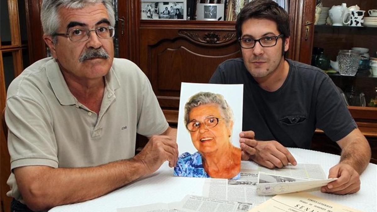 Joaquim Teixidor, junto a su hijo, muestra una foto de su madre, Maria Poch, desaparecida en el 2004.