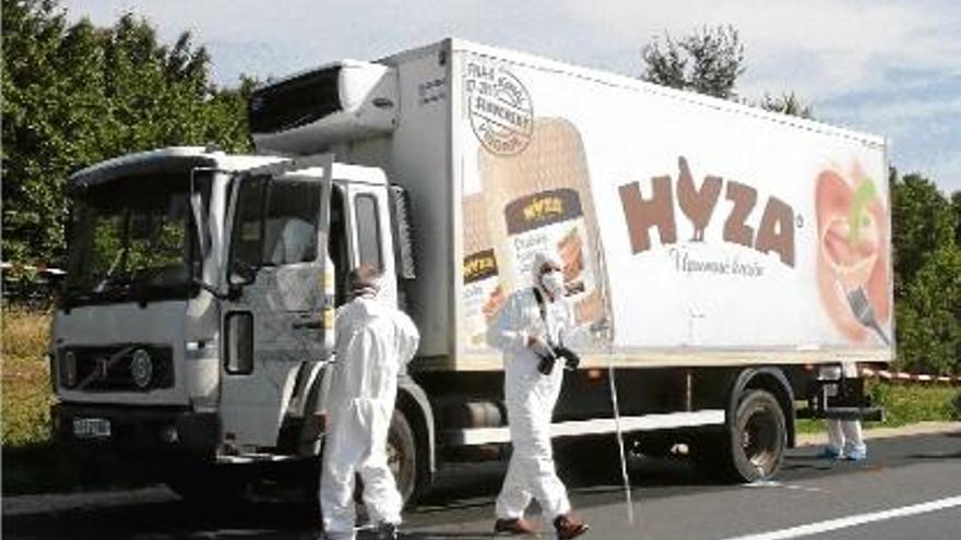 Diversos policies inspeccionen el camió on es va fer la macabra troballa a Àustria.